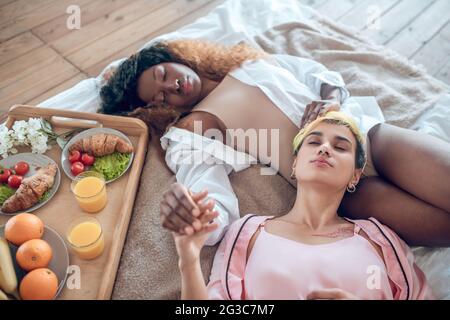 Weibliches Paar liegt berühren mit Ruhe auf dem Bett Stockfoto