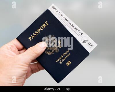 Costa Mesa, CA - 14. Juni 2021: Mann mit Pass und offizieller Covid-19 Impfpass Stockfoto