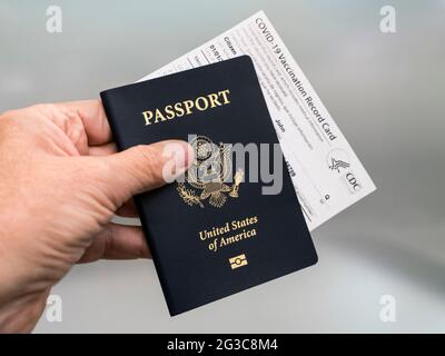 Costa Mesa, CA - 16. März 2021: Die Hand des Mannes hält einen Pass und die offizielle Covid-19 Impfkarte Stockfoto