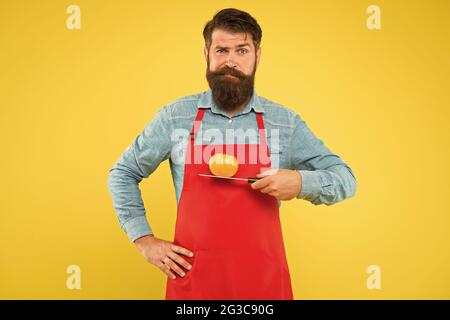 Ernährung und auch Ihr Körper verdient es. Bärtiger Mann hält Tomate auf dem Messer. Vegetarische Ernährung und Diät. Kochen für die Gesundheit. Ausgewogene Mahlzeit. Gesundes Menü Stockfoto