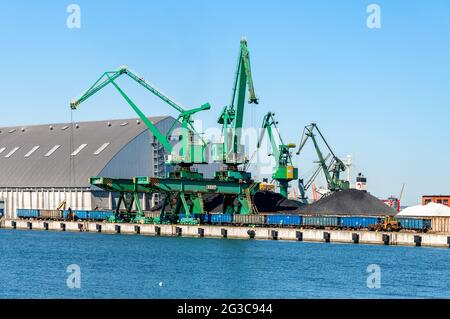 Gdynia Hafen in Polen. Das Dock mit Hafenkranen, Zug und Stapel von Kohle und andere lose Ladung Stockfoto