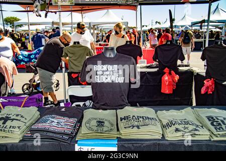 T-Shirts für rechtsextreme Politik und Waffenbegeisterung stehen auf einer Waffenmesse im Freien in Costa Mesa, CA, zum Verkauf. Beachten Sie die Maske aufgrund des Coronavirus pande Stockfoto