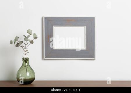 Leerer Rahmenhintergrund nachahmen. Leerer dekorativer Rahmen für ein Foto oder Gemälde in einem hellen skandinavischen minimalistischen Interieur an einer weißen, sauberen Wand. Hochwertige Fotos Stockfoto
