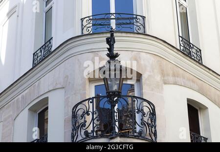 Typische und alte Metall-Straßenlampe, die auf dem Gebäude aufgehängt ist. Laterne, die an der Hauswand hängt. Paris Stockfoto