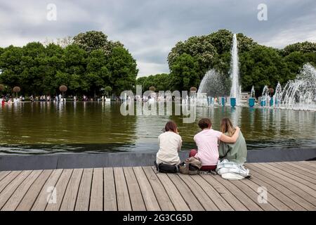 Moskau, Russland - Mai, 2021, Gorki Central Park of Culture and Leisure. Die Menschen ruhen auf dem Pier in der Nähe des künstlichen Teiches in der Nähe des Fontain Stockfoto