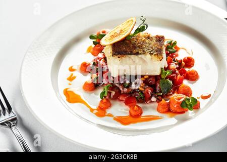 Hechtfilet auf Gemüseplatte, Nahaufnahme, heller Hintergrund Stockfoto