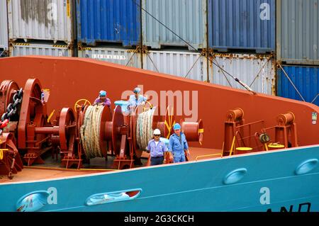 Matrosen auf einem großen Frachtschiff und Containerschiff im Hintergrund Stockfoto