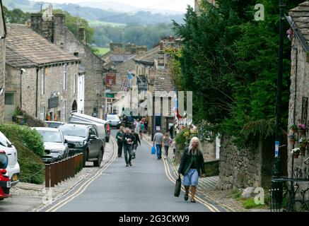 Die Menschen gehen die Straßen von Grassington in den Yorkshire Dales hinauf. Die Stadt wurde kürzlich genutzt, um die neue Serie der klassischen TV-Serie All zu Filmen Stockfoto