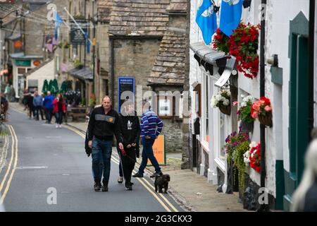 Die Menschen gehen die Straßen von Grassington in den Yorkshire Dales hinauf. Die Stadt wurde kürzlich genutzt, um die neue Serie der klassischen TV-Serie All zu Filmen Stockfoto