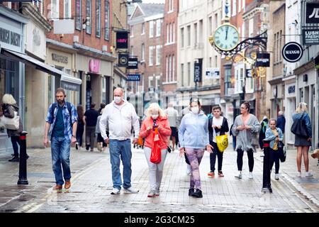 Eine Familie mit Gesichtsmasken geht entlang der Coney Street, einer der Haupteinkaufsstraßen in York, North Yorkshire. Stockfoto