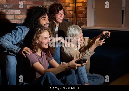 Studenten genießen, im Video zu spielen gam.friends haben Spaß während des Spiels , aufgeregt Millennial verschiedene amerikanische Freunde haben Spaß mit Joysticks im Leben Stockfoto