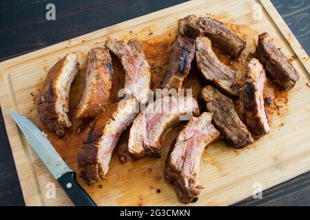 Barbecue Baby Back Ribs auf einem Bambus Schneidebrett: Schweinerippen auf einem hölzernen Schnitzbrett Stockfoto