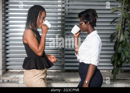 Zwei Geschäftsfrauen trinken Kaffee im Freien. Konzept Für Die Work Balance Stockfoto