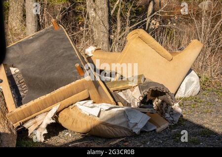 An einem sonnigen Tag mit starkem Kontrast wurden die Möbel draußen auf der Straßenseite gelassen, damit der Müllwagen abholte Stockfoto