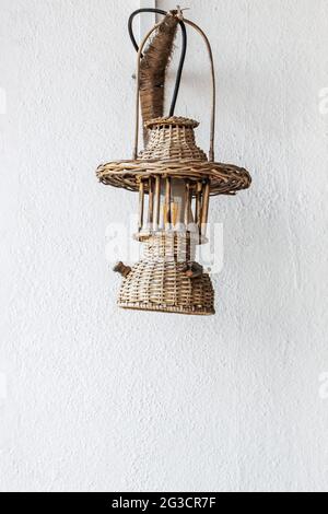 Dekoration Vintage Rattan Lampe an der weißen Wand Stockfoto