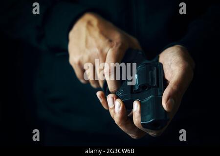 Guy hält Revolver in den Händen. Nahaufnahme von Schusswaffen. Waffe zur Verteidigung oder zum Angriff. Stockfoto