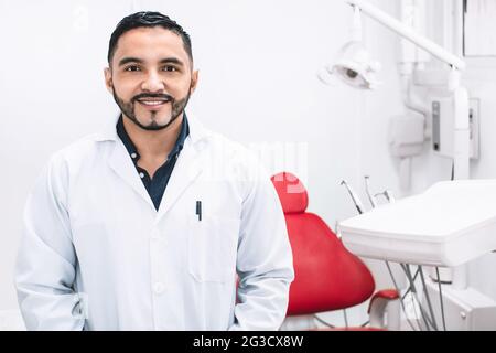 Lächelnder lateinamerikanischer Zahnarzt in einer Klinik Stockfoto