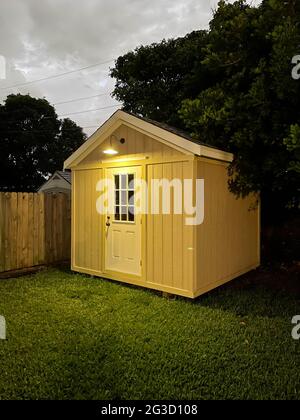 Hinterhof-Werkzeug Schuppen draußen in einem Hof während der Nacht. Viele Bäume umgeben den Schuppen. DIY-Projekt Stockfoto