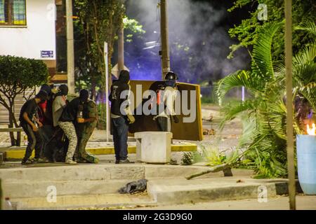 Demonstranten der Frontline vor Tränengaskanistern und Stuntgranaten hinter einer Matratze, als Demonstranten und die kolumbianische Bereitschaftspolizei (ESMAD) in der Nacht des 14. Juni 2021 in Yumbo - Cali, Valle del Cauca - Kolumbien während regierungsnahe Proteste in der 7. Woche gegen die Regierung von Präsident Ivan Duque enthüllen, waren mindestens 70 Tote durch Unruhen und Gewalt zu Tode gekommen. Stockfoto
