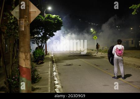 Demonstranten der Frontline vor Tränengaskanistern und Stuntgranaten hinter mehreren handgefertigten Schilden, als Demonstranten und die kolumbianische Bereitschaftspolizei (ESMAD) in der Nacht des 14. Juni 2021 in Yumbo - Cali, Valle del Cauca - Kolumbien während regierungsnahe Proteste in der 7. Woche gegen die Regierung von Präsident Ivan Duque enthüllen, waren mindestens 70 Tote durch Unruhen und Gewalt zu Tode gekommen. Stockfoto