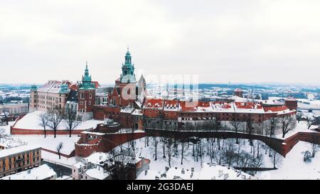 Drohnenansicht des Königsschlosses Wawel. Ein Schloss Residenz im Zentrum von Krakau. Ein berühmtes Wahrzeichen. Panoramablick auf die Skyline der Stadt während der Wintersaison. Der klare weiße Himmel im Hintergrund. Stockfoto