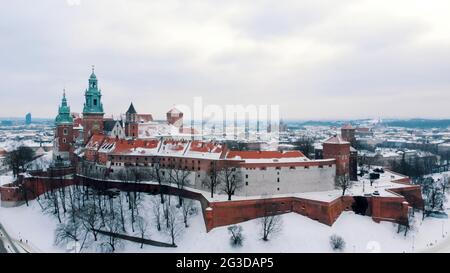 Luftaufnahme des königlichen Schlosses Wawel. Ein Schloss Residenz im Zentrum von Krakau. Ein berühmtes Wahrzeichen. Panoramablick auf die Skyline der Stadt während der Wintersaison. Der klare weiße Himmel im Hintergrund. Stockfoto