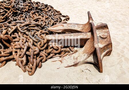 Riesige rostige Ankerketten mit Schiffsanker eines alten Schiffes am Sandstrand Stockfoto