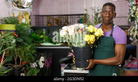 Lächelnder Blumenhändler mit Blumen Stockfoto