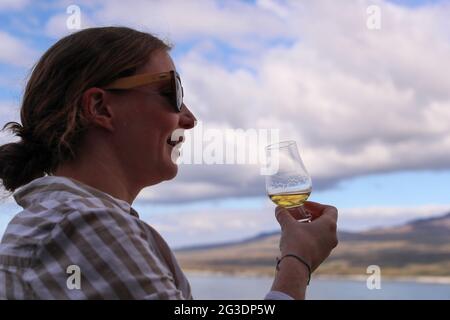 Trinken Sie Whisky in der Ardnahoe Distillery auf der Isle of Islay an der Westküste Schottlands mit den Paps des Jura am Horizont. Stockfoto