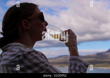 Trinken Sie Whisky in der Ardnahoe Distillery auf der Isle of Islay an der Westküste Schottlands mit den Paps des Jura am Horizont. Stockfoto