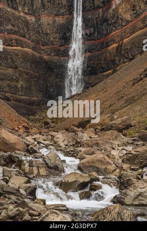 Hengifoss Wasserfall in Ostisland. Hengifoss ist der dritthöchste Wasserfall Islands und wird von basaltischen Schichten mit roten Tonschichten umgeben Stockfoto