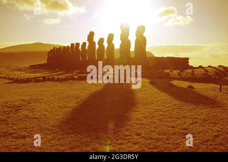 Sonnenaufgang über der Silhouette der Moai-Statuen auf der himmlischen Plattform von Ahu Tongariki auf der Osterinsel, Chile, Südamerika in goldener Farbe Stockfoto