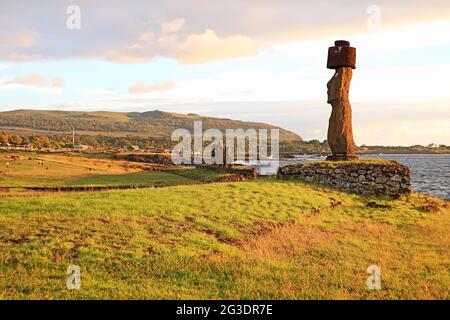 Moai mit Pukao (Hut) von Ahu Ko Te Riku Feierliche Plattform, mit Gruppe von Moai von Ahu Tahai im Hintergrund, Pazifikküste, Osterinsel, Chile Stockfoto