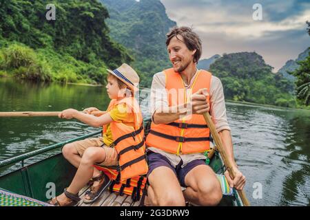 Glückliche Familien-Touristen in Trang an Scenic Landscape Complex in Ninh Binh Provinz, Vietnam EIN UNESCO-Weltkulturerbe. Wiederaufnahme des Tourismus in Stockfoto