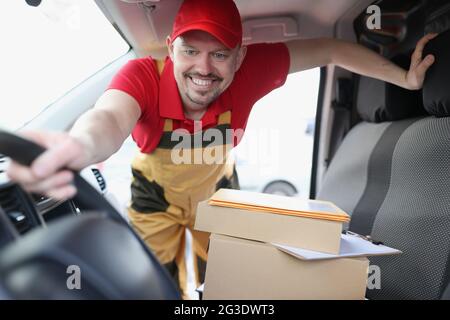 Kurierfahrer holt Kartons im Auto ab Stockfoto
