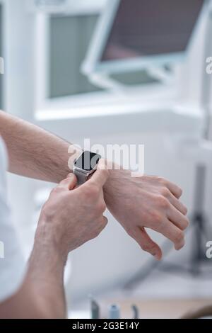 Nahaufnahme eines männlichen Arms mit einer Smartwatch Stockfoto