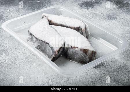 Tiefkühlset für grönländische Heilbutt-Steaks, auf grauem Steintisch-Hintergrund, mit Platz für Text Stockfoto