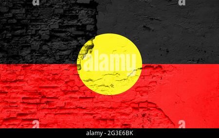 Die australische Aborigine-Flagge ist auf eine alte Ziegelmauer gemalt Stockfoto