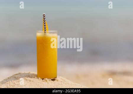 Frucht-Mango-Cocktail im Hintergrund des Strandes Stockfoto