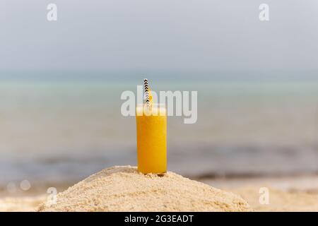 Frucht-Mango-Cocktail im Hintergrund des Strandes Stockfoto