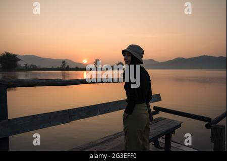 Schöne junge asiatische Frau genießen mit Sonnenaufgang auf Bergsee am Morgen Stockfoto