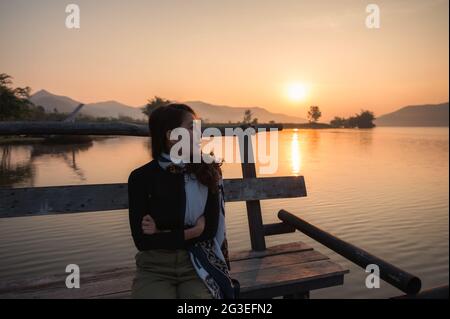 Schöne junge asiatische Frau genießen mit Sonnenaufgang auf Bergsee am Morgen Stockfoto