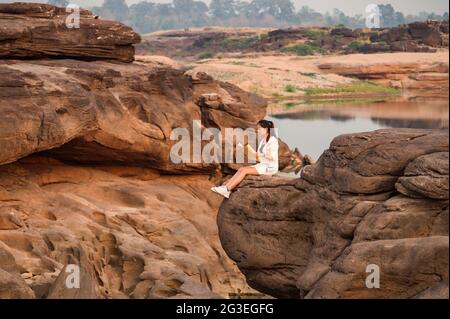 Junge asiatische Frau, die auf einer Karte auf einer Felsklippe im Grand Canyon von Thailand nachschaut Stockfoto