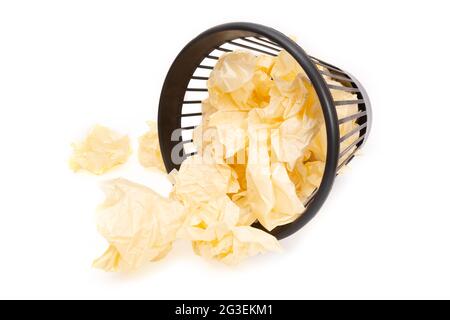 Heruntergefallener Bürokorb voller zerknitterter Papierkugeln, isoliert auf Weiß Stockfoto