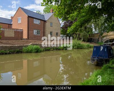 Neue Häuser werden an der Seite des Grand Union Kanals, Cosgrove, Northamptonshire, Großbritannien, gebaut Stockfoto