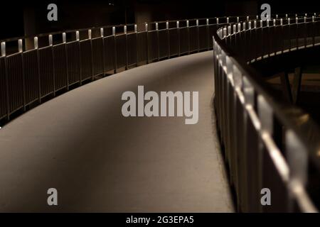 Parkweg bei Nacht. Das Licht der Fanaren auf der Uferbrücke. Weg im Dunkeln. Platz für einen Spaziergang. Stockfoto