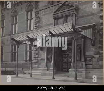 Osteingang mit Markise; Osteingang in der Nordfassade. Eingang auf der Nordseite des Turms II mit Zugangstür und Vordach auf gusseisernen Säulen. Auf beiden Seiten der Tür befinden sich Bilder von Frauen, über der Markise befindet sich ein Käfig unter einem Pauken mit dem Text Holländisches Museum. Links ist ein Teil der façade-Fassadenwand I-II Stockfoto