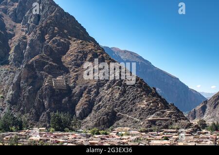 Blick über die Stadt Ollantaytambo auf die archäologische Stätte Pinkuylluna mit Perus heiligem Tal im Hintergrund Stockfoto