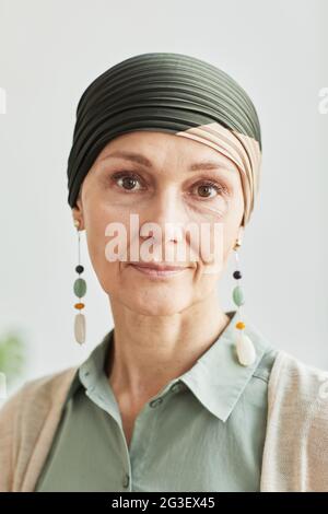 Vertikale Nahaufnahme Porträt einer reifen Frau mit Kopftuch und Blick auf die Kamera ruhig Stockfoto