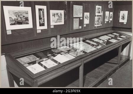 Raum des KOG mit verschiedenen Objekten an der Wand und in Vitrinen, darunter Zeichnungen und ein Schachspiel; die niederländische Ausstellung in japanischen Lagern. An der Wand, unten in der Mitte, das Cover einer burmesischen Zeichenzeitschrift, die dem Zeichner vom Lagerkommandanten, der sich selbst unterschrieb, geschenkt wurde. Stockfoto